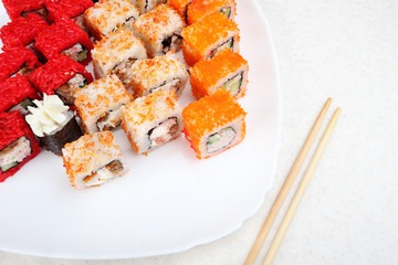 Sushi set on a white plate. Several varieties of sushi and chopsticks. Japanese traditional food.