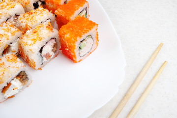 Sushi set on a white plate. Several varieties of sushi and chopsticks. Japanese traditional food.