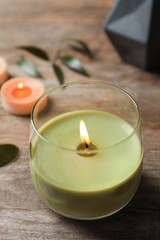 Fototapeta na wymiar Beautiful burning wax candle on wooden table