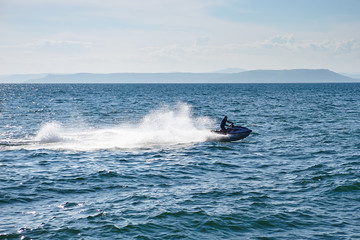 man speeding on jet ski on sea during summer vacation