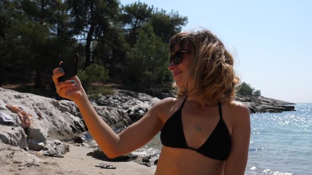 Young happy woman enjoy take selfie picture during summer sea beach leisure in Greece