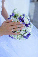 Beautiful bride is holding a wedding colorful bouquet