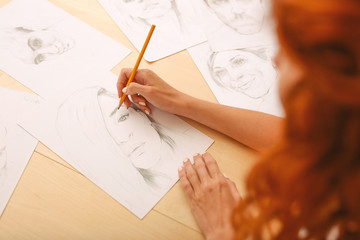 Nice portrait. Beautiful beaming girl with long curly foxy hair feeling inspired while drawing nice...