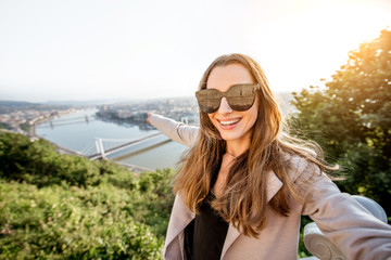 Young pretty woman making selfie photo on the beautiful cityscape background in Budapest city, Hungary