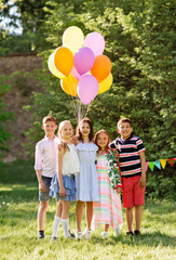 holidays, childhood and celebration concept - happy kids with balloons on birthday party at summer park