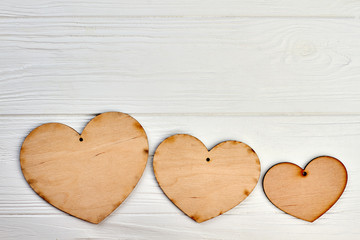 Fototapeta premium Three wooden hearts and copy space. Row of blank plywood hearts and space for text.