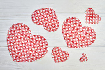Red paper hearts on white wooden background. Set of red patterned hearts for banner on white wood. Valentines holiday handmade greeting cards.