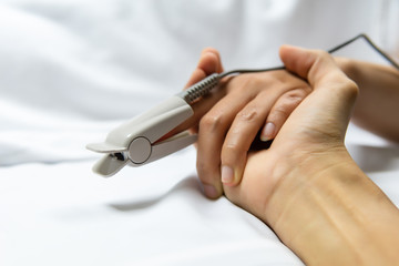 Medical and healthcare concept, Doctor or nurse holding patient woman hand on the bed, measuring heart rate