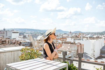 Woman enjoying great cityscape view from the terrace on the old town in Budapest city, Hungary