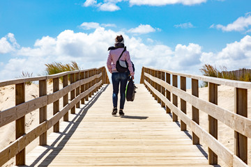 Woman on the wooden pier to the sea