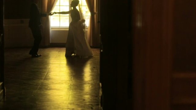 Moving view at the dancing walz couple of newlyweds in the old baroque castle. Happy wedding moments.
