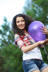 Young woman with a purple balloon in her hands.