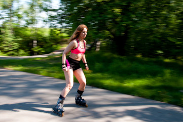 Roller skating woman in park rollerblading on inline skates.