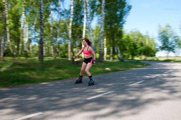 Roller skating woman in park rollerblading on inline skates. Beautiful woman learns to roller skate...