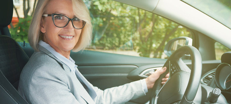 Aged Woman Toothy Smiling While Driving A Car