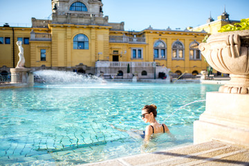 Woman relaxing with water jet massage at the famous Szechenyi thermal bathes in Budapest, Hungary - obrazy, fototapety, plakaty