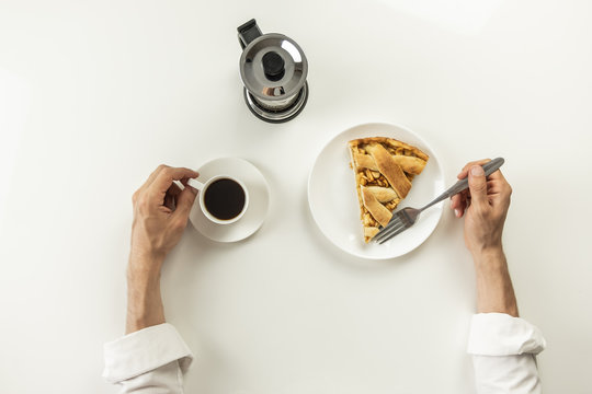 Top view of minimalistic table with business lunch with coffee, cereal and applie pie. Male hands holding cup of black coffee and fork having breakfast with granola snack and piece of cake.