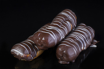 Cake chocolate eclairs on a dark background close up