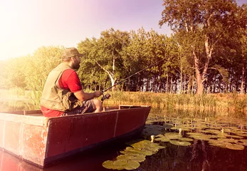 Gordijnen Calm man sitting in boat and fishing © Cherries