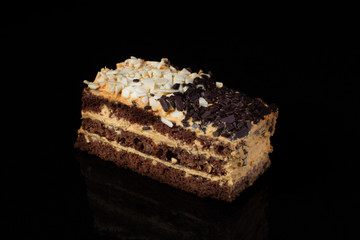 Piece of cake with white and black chocolate on a black background.Russian cake day and night