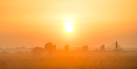 Sunset in the city. Skyline with orange sun on sky