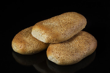 Buns with sesame seeds on a dark background. Loaf