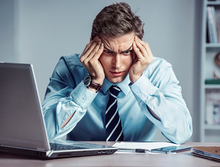 Young worker sitting in his office thinking. Business concept