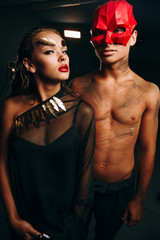 A girl with a beautiful Mayk and a guy with a naked torso.The guy in the red mask