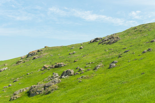 A picturesque panoramic view on green hills with rocks on a summer day in Saharna, Moldova