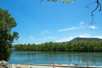 Fishing boat on the Barron River and plane in the skies near Cairns in Tropical North Queensland,...
