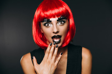 The girl in the red wig on a dark background