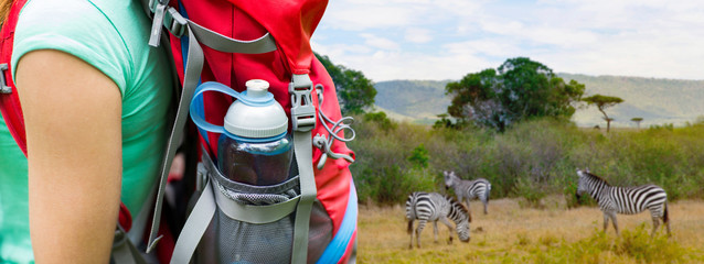 travel, tourism, hike and people concept - close up of woman with water bottle in backpack pocket...