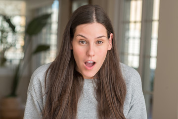 Young beautiful woman at home afraid and shocked with surprise expression, fear and excited face.