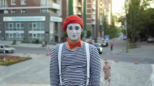 Funny mime has fun at fountain background