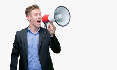 Young handsome blond man holding a megaphone with a happy face standing and smiling with a confident smile showing teeth