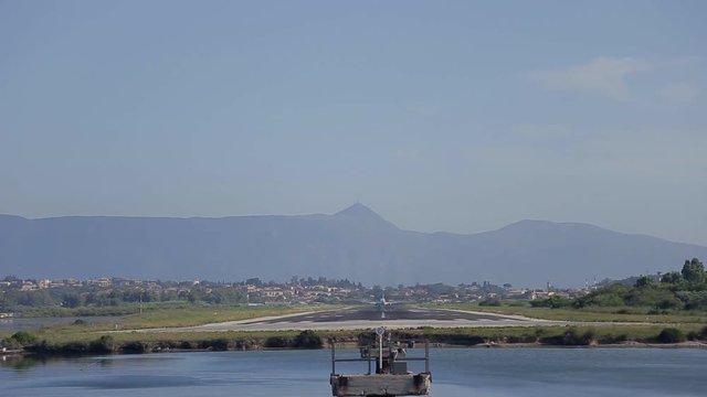 the plane approach and landing at Kerkira airport at summer day above the sea