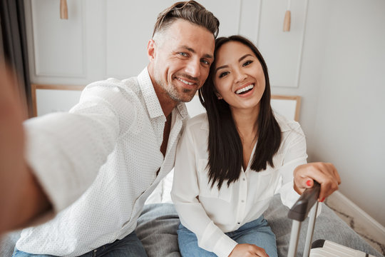 Joyful young couple taking selfie with mobile phone