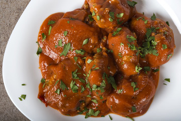 Meatballs with tomato sauce and fresh chopped parsley on plate