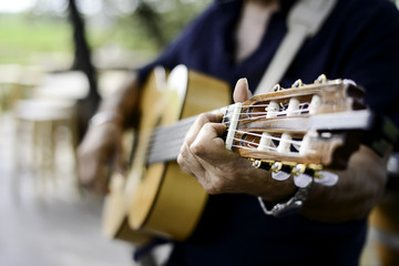 closeup detail hand playing folk guitar outdoor summer festival