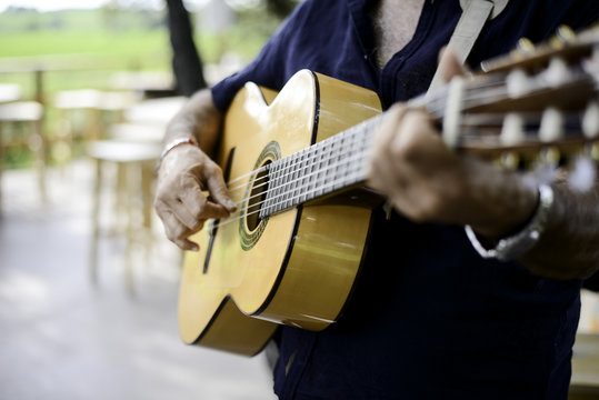 closeup detail hand playing folk guitar outdoor summer festival