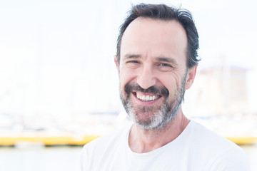 Fototapeta premium Handsome senior man traveling on sailboat and smiling happy and confident