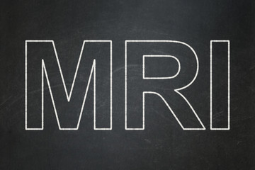 Medicine concept: text MRI on Black chalkboard background