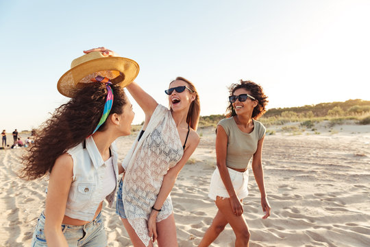 Three excited girls friends in summer clothes