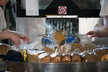Industrial line for packaging of bakery products. Packing of bread at the factory.The machine for cutting and packing in a factory for the production of bread.