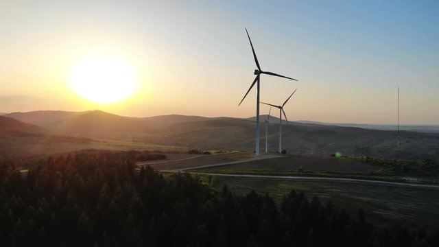wind turbines at sunset convertation green energy panoramic aerial view environment pollution problems human being eco-system technology bright sun light rising future of planet Earth new generation