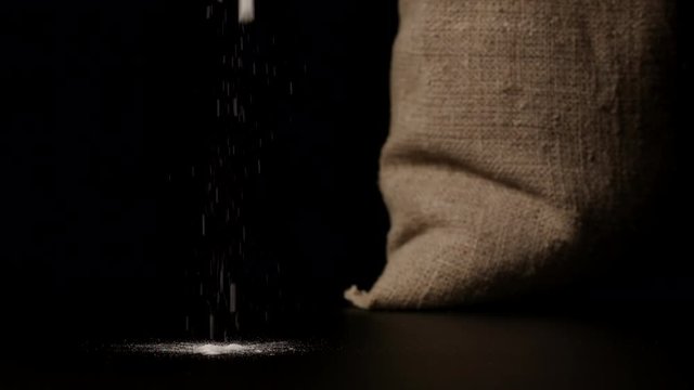 SLOW MOTION: White flour falling down near a sac