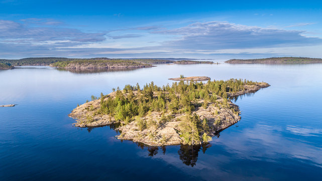 Nature of Russia. The Republic of Karelia. Reflection of clouds in the water. Islands on the horizon. Wild nature. Calm on the lake. Karelia Ladoga Lake.