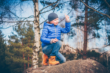 Young red-haired adventurer determines the direction of the wind with the help of a finger