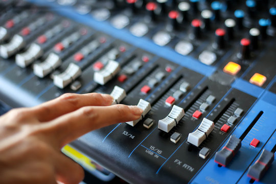 hand using mixing console,Sound recording studio mixing desk with engineer or music producer