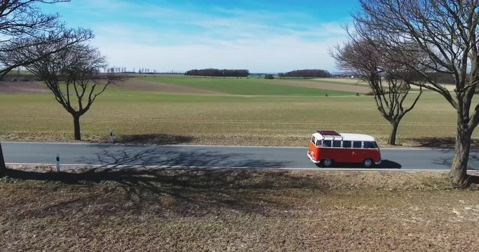 Road trip friends in hippie car. Aerial view of a retro van. Summer holidays, road trip in orange minivan car